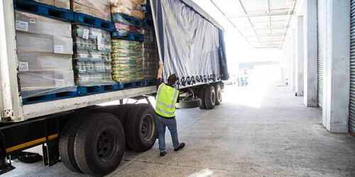 Worker loading a lorry at a large warehouse